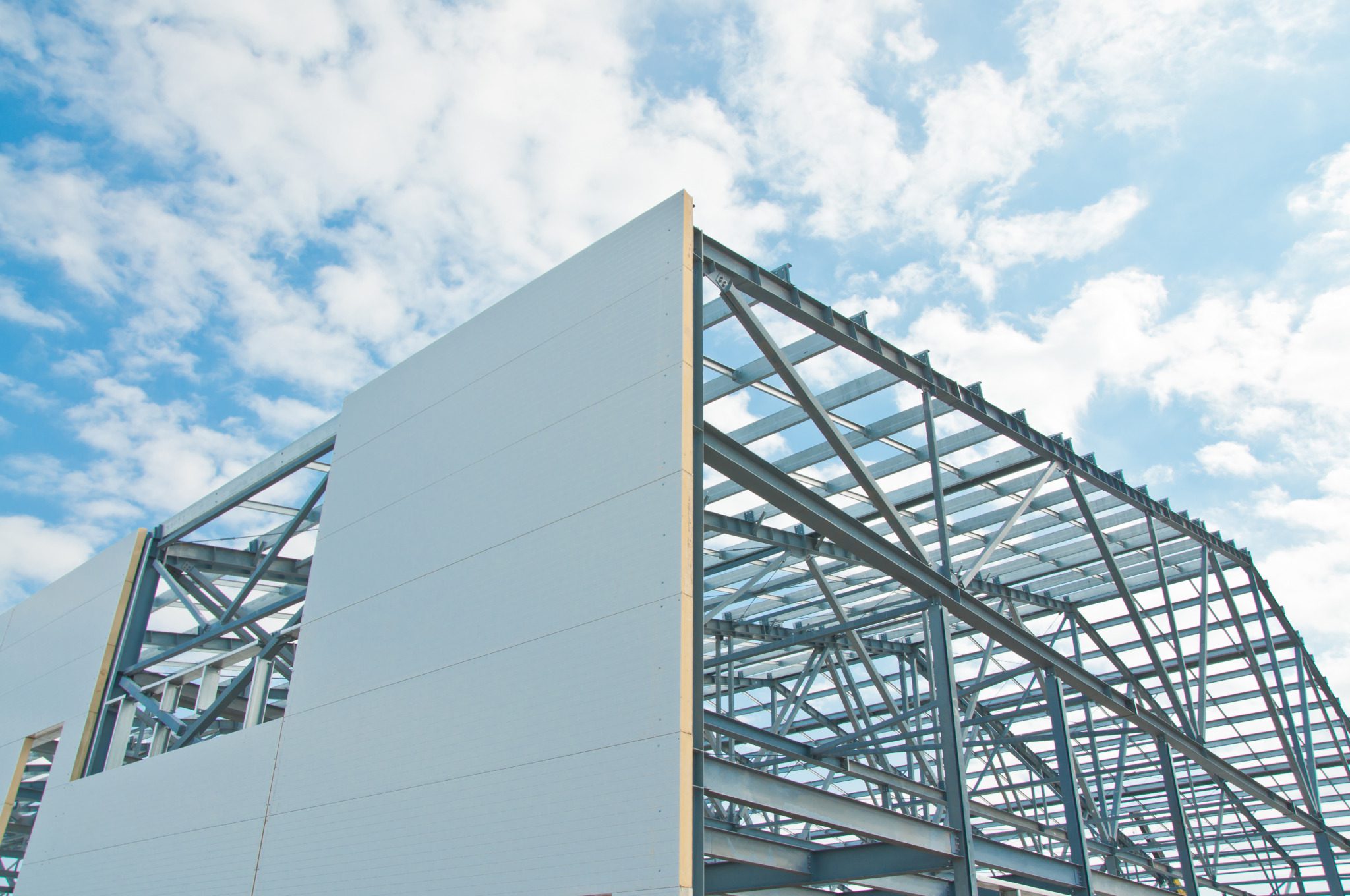 Metal frame of the building with a sandwich panel of insulation on the wall. Construction of a new industrial building. Building with insulated metal wall panels